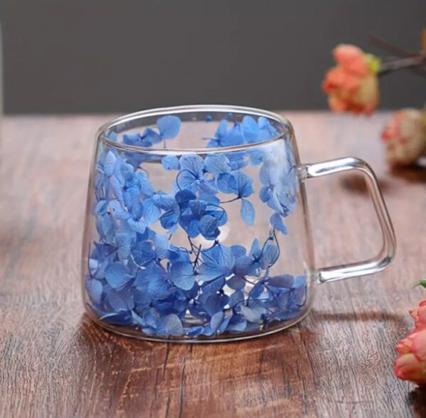 A stunning double-walled glass mug filled with  floral accents