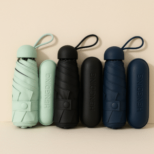Compact capsule-style umbrella in green, black, and dark blue